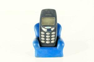 een blauw plastic stoel met een oud mobiele telefoon in het foto