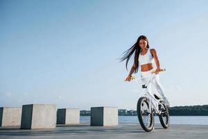 vrouwelijke rijder is overdag op de fiets in de buurt van het meer. fitness vrouw in sportieve kleding foto