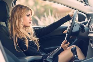 blondie jonge vrouw rijdt in een sportwagen foto