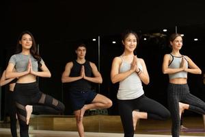 yogales van jongeren die geïnteresseerd zijn in yoga-activiteiten met een yogaleraar foto