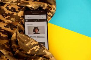kiev, Oekraïne - 4 kunnen, 2023 vandaag ua oekraïens nieuws portaal Aan smartphone scherm met oekraïens vlag en camouflage kleding stof foto
