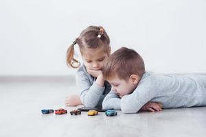 kinderen die thuis digitale gadgets gebruiken. broer en zus in pyjama tekenfilms kijken en spelletjes spelen op hun technologietablet foto