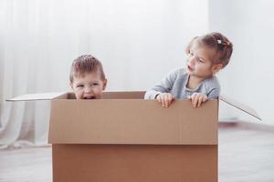 twee kleine kinderen jongen en meisje zijn net verhuisd naar een nieuw huis. concept foto .. kinderen hebben plezier.