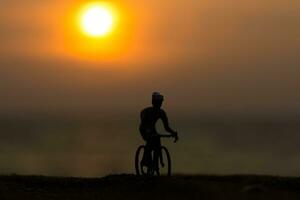 silhouetten fietsers Aan de strand Bij zonsondergang. foto