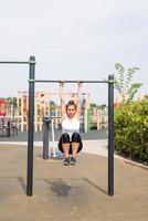 gelukkige vrouw die op het sportveld traint op een zonnige zomerdag foto