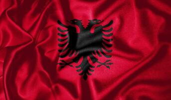 Albanië vlag golvend fladderend in de wind met realistisch structuur kleding stof zijde satijn achtergrond foto