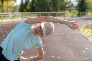 een jong mooi vrouw in sportkleding Toneelstukken sport- Bij een lokaal stadion foto