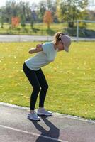 een jong mooi vrouw in sportkleding Toneelstukken sport- Bij een lokaal stadion foto