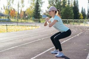 een jong mooi vrouw in sportkleding Toneelstukken sport- Bij een lokaal stadion foto