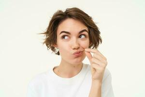 beeld van jong vrouw maakt belofte naar houden geheim, shows mond ritssluiting gebaar, zet een zegel Aan haar lippen, niet praten teken, staat over- wit achtergrond foto