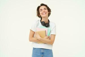 beeld van zorgeloos, glimlachen vrouw met notitieboekjes, lachend en op zoek Vrolijk, poseren over- wit achtergrond foto