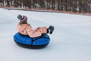 mensen die op snowtubing rijden in het winterpark foto