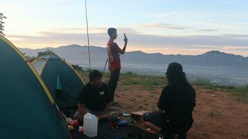 gorontalo, Indonesië - december 10, 2023 - een groep van mannetje klimmers zijn genieten van de ochtend- atmosfeer Bij de top van arang heuvel foto