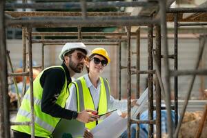 ingenieur en architect werken Aan de bouw plaats, dubbel checken plannen en werkwijze. foto