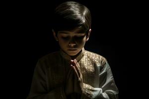 ai gegenereerd een jong jongen bidden in een verduisterd kamer foto