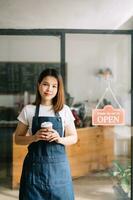 opstarten geslaagd klein bedrijf eigenaar mkb vrouw staan met tablet in cafe restaurant. vrouw barista foto