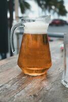 bier in een glas pot met hand- Holding foto