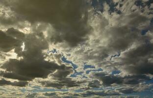 een blauw bewolkt lucht met veel klein wolken blokkeren de zon foto