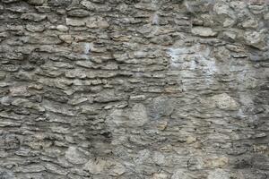 heel oud steen steen muur van kasteel of vesting van 18e eeuw. vol kader muur met verouderd vuil en gebarsten bakstenen foto