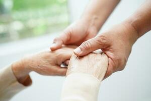 arts hand in hand Aziatische oudere vrouw patiënt, hulp en zorg in het ziekenhuis. foto