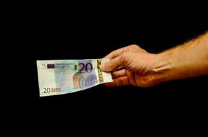 een hand- Holding een twintig euro bank Notitie foto