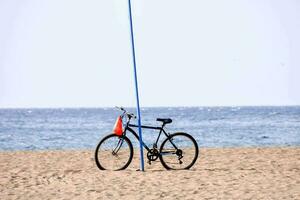 een fiets is geparkeerd Aan de strand in de buurt een pool foto