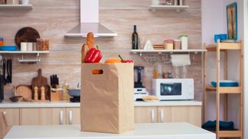 supermarkt papieren zak in keuken met vers groenten Aan tafel top. biologisch levensstijl gezond jong aankoop van supermaket, vers groenten boodschappen boodschappen doen zak foto