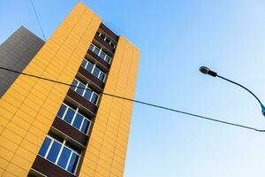 geel huis, stad lamp met draad en blauw lucht foto