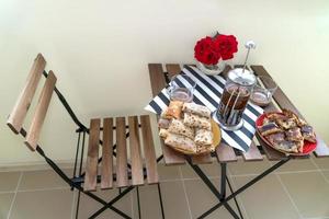 een houten stoel en een klaptafel met ontbijt op het balkon foto