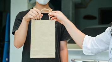 hand-to-hand bestelproducten en eten thuisbezorgd om de overdracht van het coronavirus of kovid-19 te voorkomen. foto