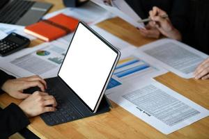 zakenvrouw werkt op het scherm van de tabletcomputer leeg met grafieken en diagrammen op het bureau. foto