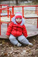 de kind is spinnen Aan een schommel in de speelplaats in de park foto