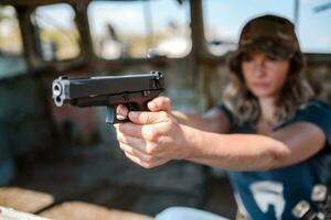 vrouw met een pistool in haar hand- leert naar schieten foto