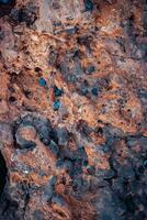 rood getextureerde rots achtergrond foto. detailopname blauw verspreide in de steen. zandsteen foto