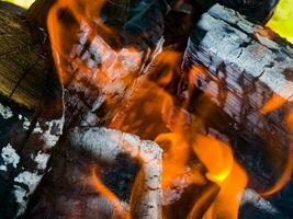 detailopname van een brand met brandhout, kolen en as. foto