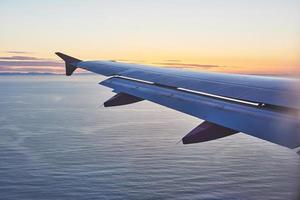 orning zonsopgang met vleugel van een vliegtuig. foto toegepast op touroperators. afbeelding voor tekstbericht of framewebsite. reizen concept