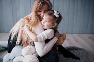 gelukkige liefdevolle familie. moeder en haar dochter kind meisje spelen en knuffelen foto