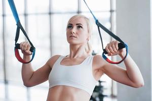 vrouwen doen push-ups training armen met trx fitness bandjes in de sportschool concept workout gezonde levensstijl sport foto