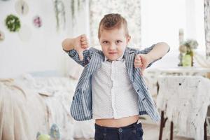 jongen gebaart zijn vinger naar beneden. emotie begrip. toont zijn houding ten opzichte van lessen en scholen foto