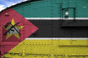 Mozambique vlag afgebeeld Aan kant een deel van leger gepantserd tank detailopname. leger krachten conceptuele achtergrond foto