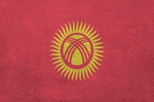 Kirgizië vlag afgebeeld in helder verf kleuren Aan oud Verlichting bepleistering muur. getextureerde banier Aan ruw achtergrond foto