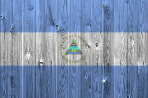 Nicaragua vlag afgebeeld in helder verf kleuren Aan oud houten muur. getextureerde banier Aan ruw achtergrond foto