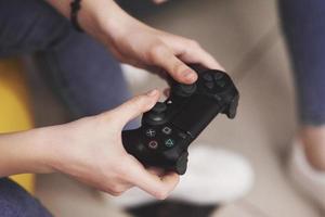 de vrouw speelt op de console en houdt de joystick in haar handen foto