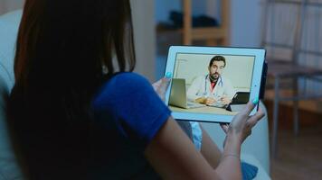 afgelegen geduldig gebruik makend van tablet hebben video conferentie met dokter. foto