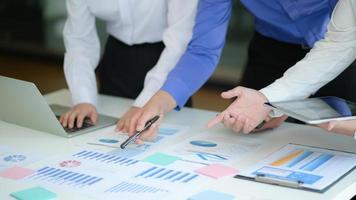 Office-team analyseert de resultaten van het bedrijf uit de gegevensgrafiek voor managementvoorstellen.