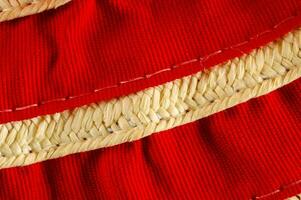 detailopname van rood kleding stof met geweven trimmen foto