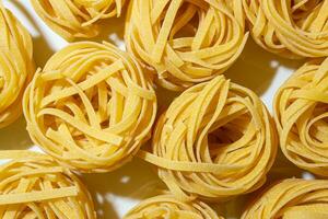ongekookt ei-gebaseerd fettuccine pasta. een culinaire canvas van lintvormig macaroni, creëren een levendig en getextureerde achtergrond voor fijnproever Koken. droog pasta. rauw macaroni - top visie, vlak leggen foto