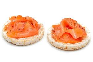 smakelijk rijst- taart boterhammen met vers Zalm plakjes geïsoleerd Aan wit. gemakkelijk ontbijt en eetpatroon voedsel. knäckebröd met rood vis. gezond dieet snacks isolatie foto