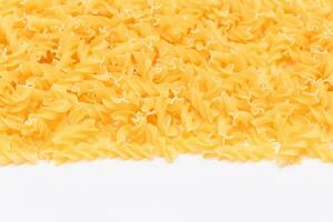 ongekookt fusilli pasta met kopiëren ruimte Aan wit achtergrond. rauw en droog macaroni. dik en ongezond voedsel vlak leggen foto