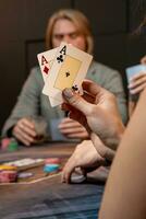 twee azen in hand- van vrouw spelen poker Bij gaming tafel foto